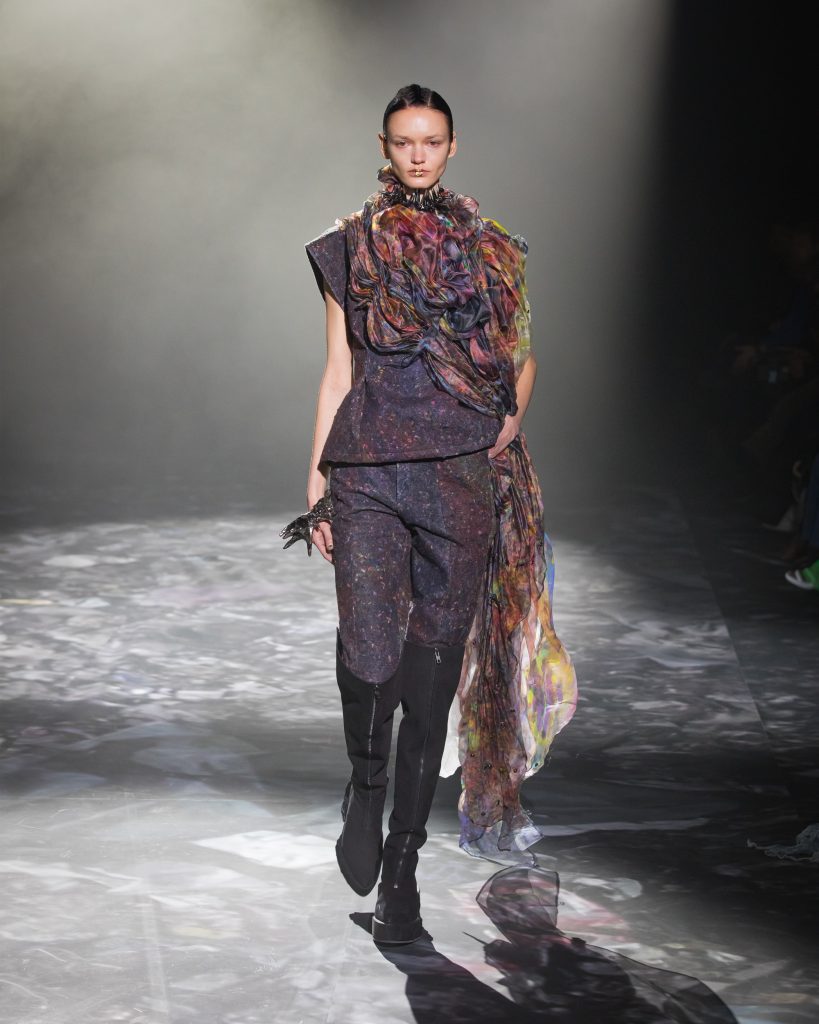Fashion designer showcasing a digitally printed vibrant garment on the runway.