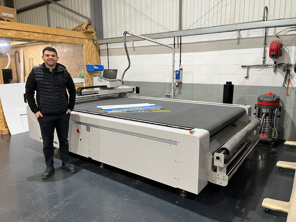 Sign & Labels' Ross Hughes stands alongside the new VeloBlade Nexus 2516 wide-format digital die cutter